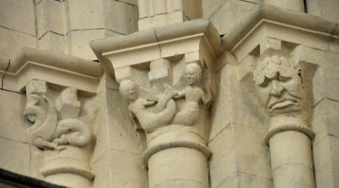 Chapiteaux du roman tardif sur la façade occidentale nord : dragon,  sirènes et énorme masque.