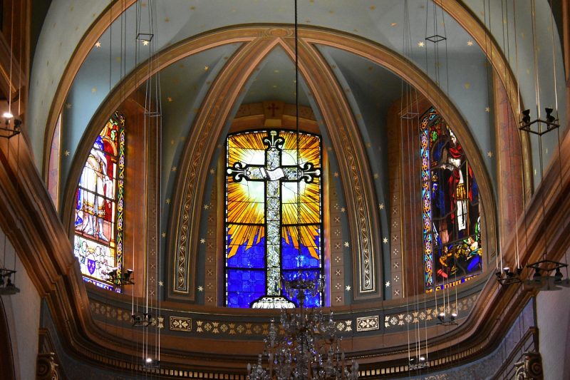 Les trois vitraux du chœur au sein d'une ornementation restaurée en 2019
