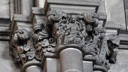Chapiteau dans la nef avec une sainte ouvrant les bras au milieu de  thèmes floraux variés