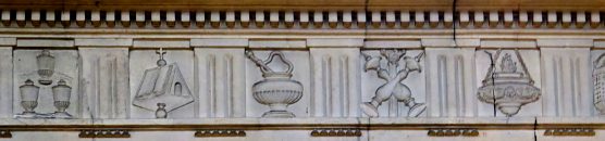 La frise qui accompagne la corniche est ornée de symboles liturgiques et des instruments de la Passion