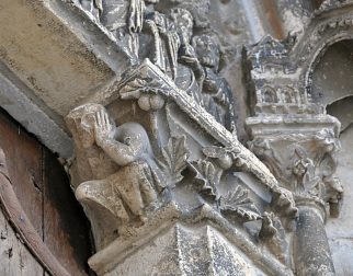 Sous le linteau du portail central, bas–relief d'un homme se bouchant les oreilles pour ne pas entendre la parole divine