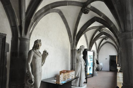 La galerie du 1er étage présente des statues et des panneaux  d'information.