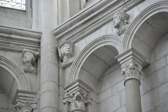 Série de têtes sculptées au sommet des arcatures cintrées du faux triforium du chœur Renaissance.
