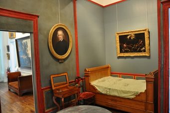 Petite salle du premier étage avec lit et tableaux