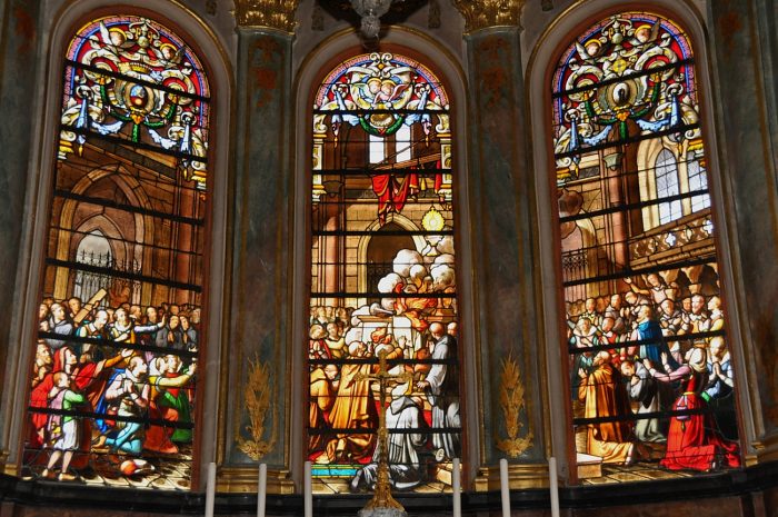 Le vitrail de l'abside de la Sainte–Chapelle illustre le miracle de Faverney : l'ostensoir est épargné par les flammes