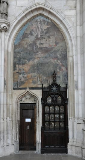 Porte gothique et meuble avec ses panneaux peints du XVIe siècle. Au–dessus, fresque du Ravissement de sainte Madeleine