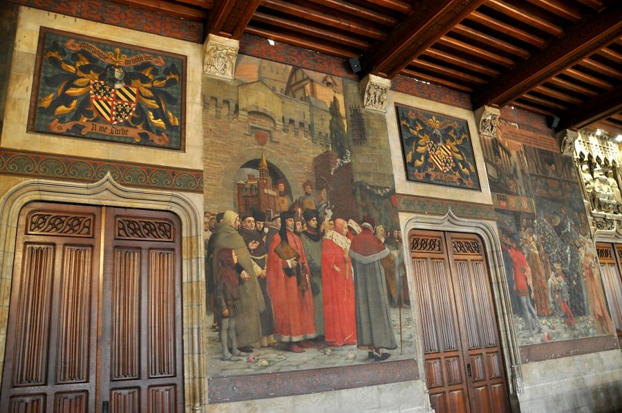 Salle du Conseil, le mur opposé aux fenêtres avec ses blasons  et ses scènes historiées