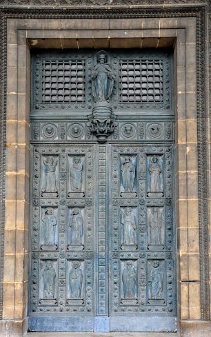 La porte principale en fonte peinte est ornée des douze apôtres