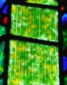 Gros plan sur la robe de sainte Geneviève dans le vitrail de l'archange Raphaël