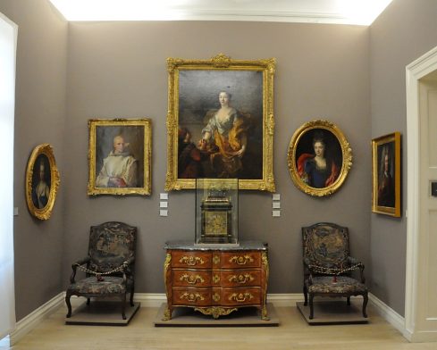 Une petite salle du musée avec tableaux et mobilier.